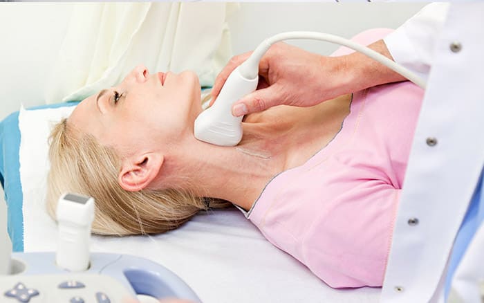 Clinician performing a carotid intima-media thickness (CIMT) ultrasound on a patient’s neck